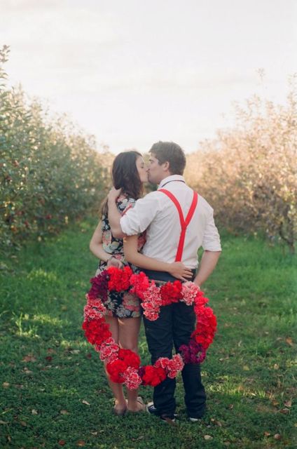 a bright floral heart-shaped wreath and red suspenders to accent this Valentine engagement photo
