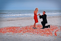 a romantic Valentine engagement on the beach in a heart made of petals is a cool and timeless idea for a Valentine’s Day