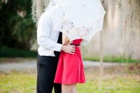 a red mini dress and a lace umbrella for pretty Valentine engagement pics with much romance and elegance