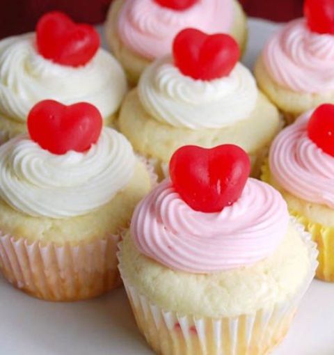 cupcakes with pink and white frosting and heart toppers are lovely Valentine wedding desserts or appetizers