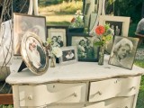 a white vintage dresser with a mirror and an arrangement of photos of relatives that are gone is a very sentimental wedding decoration