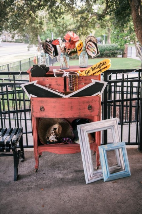 a red vintage dresser with props and signs is a great idea for a wedding photo zone