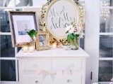 a neutral vintage dresser used for displaying wedding decor – wedding signs, candles, blooms and a photo – is a simple and cool idea