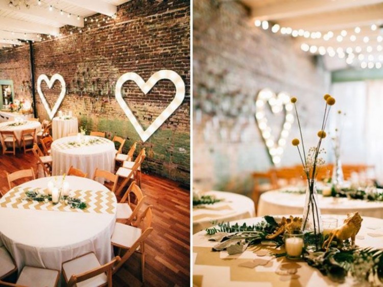 a stylish industrial wedding venue with brick walls, marquee hearts and lovely chevron runners and billy balls