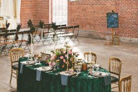 an industrial wedding venue with red brick walls, industrial pendant lamps, accented with refined and beautiful furniture and pink blooms