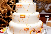 a white wedding cake with various places named, suitcases and sugar passports on top screams trips