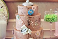 a taupe and blue wedding cake imitating postcards and letters and some twine and bows