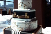 a gorgeous wedding cake featuring suitcase and map tiers and a glam embellished monogram topper