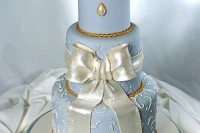 a refined and elegant serenity blue wedding cake with neutral and gold touches, with exquisite details and white roses on top for a formal vintage wedding