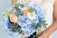 a lovely wedding bouquet of serenity blue, white and peachy blooms, greenery and evergreens is a lovely idea for summer
