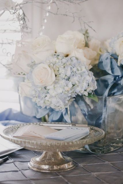 a delicate wedding centerpiece of white and serenity blue blooms is a lovely idea for a pastel spring or summer wedding