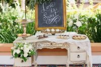 a beautiful vintage inlay dresser with lace, white florals, chalkboard, various delicious desserts and sweets