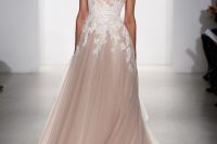 a blush A-line wedding dress with thick straps, a V-neckline, a train and white floral lace appliques is chic