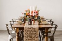 a bold wedding tablescape with a kraft paper calligraphy table runner, bold blooms and greenery, tall and thin candles and metal chairs