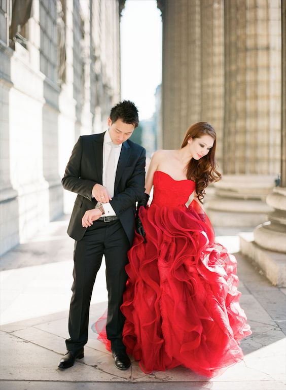 a bride-to-be wearing a strapless red dress with a layered skirt is a lovely and bold idea for a more formal engagement
