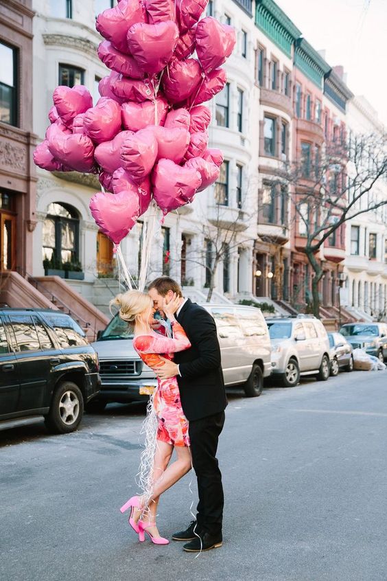 a bright floral dress, hot pink shoes and a bunch of pink heart balloons for your Valentine's Day engagement
