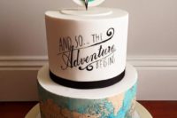 a bright wedding cake with a white calligrpahy and a map tier plus a compass topper