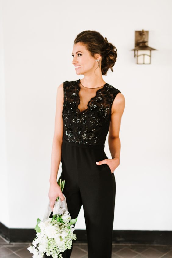a chic black sleeveless bridesmaid's jumpsuit with an illusion neckline and a shiny bodice for a wow look