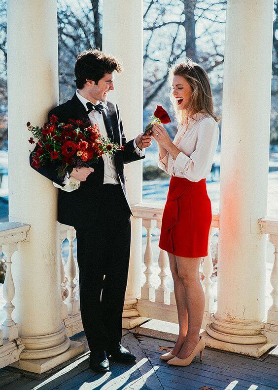 a cute Valentine's Day engagement pic with lots of red blooms to match the bridal outfit