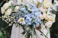 a dreamy lush wedding bouquet composed of serenity blue flowers and lots fo neutral ones, with berries and greenery is a pretty idea for a romantic spring wedding and your touch of something blue