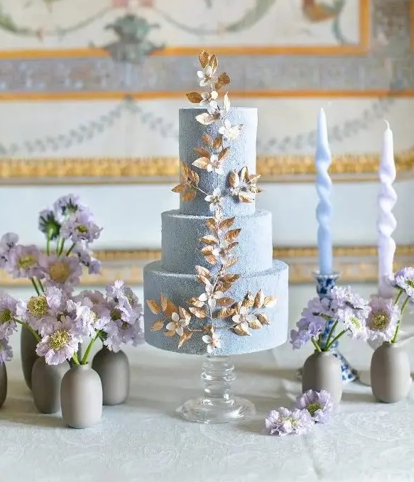 a fabulous textural serenity blue wedding cake with gold and white blooming branch detailing is amazing