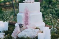 a gorgeous geode wedding cake with rose quartz and crystals on top and around the cake is very cool