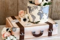a gorgeous travel-themed wedding cake with a vintage suitcase and a world map tier plus sugar blooms