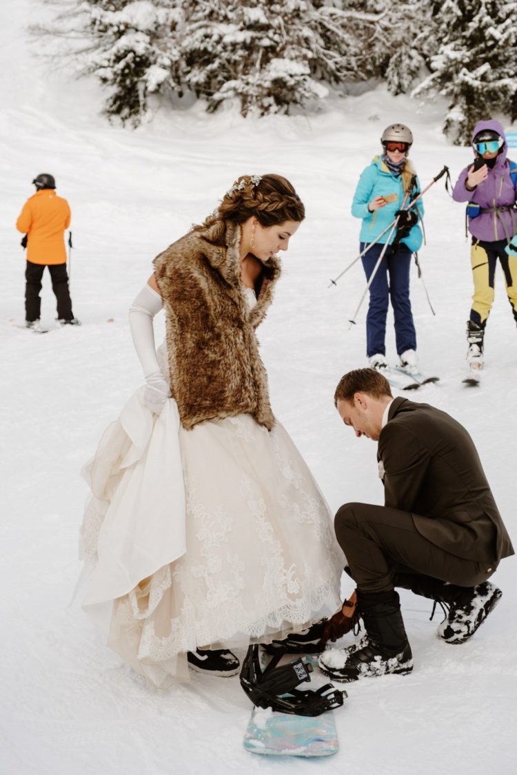 a happy couple standing on their snowboards for having fun and some cool wedding portraits