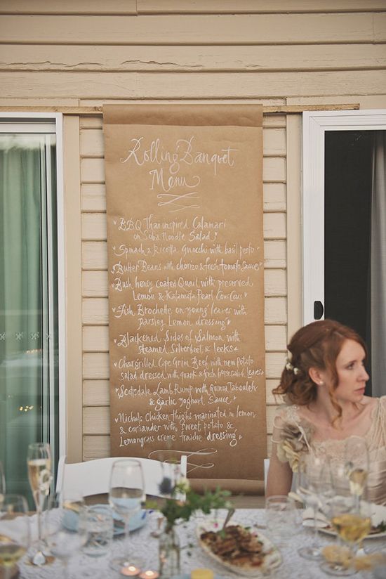 a kraft paper wedding menu with calligraphy attached right to the wall of the venue is a lovely and easy idea
