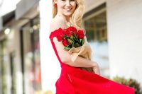 a red off the shoulder over the knee A-line dress, statement earrings and red roses for a bride-to-be