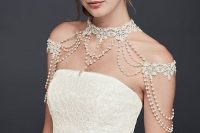 a refined white lace and pearls shoulder jewelry piece paired with a lace sheath wedding dress for a chic vintage look