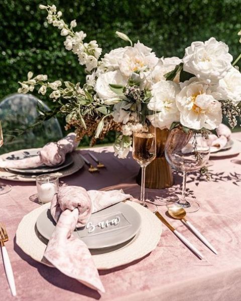 a romantic rose quartz wedding tablescape with marble linens and neutral blooms is very chic and very beautiful