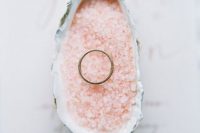 a seashell filled with pink Himalayan salt to display a wedding ring is a cool fit for a rose quartz wedding