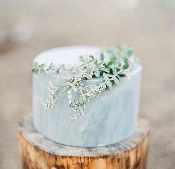 a serenity blue marble wedding cake topped with greenery for a spring or summer wedding