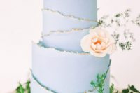 a serenity blue wedding cake with rough gold edges and a peachy bloom is a lovely idea for a spring or summer wedding