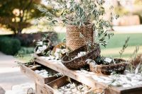 a stained rustic dresser with lots of greenery with tags is a creative idea for wedding escort cards, perfect for an Italian wedding