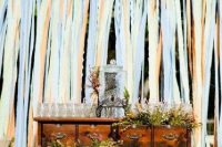 a stained vintage dresser with greenery and blooms, a drink tank and glasses with straws for a rustic wedding