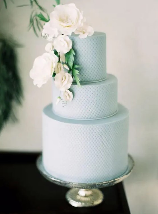 a textural serenity blue wedding cake decorated with white blooms and greenery is a great idea for a spring or summer wedding