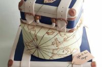 a unique wedding cake showing off two vintage suitcases and a tier with a world map plsu a tag