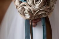 a vintage-inspired wedding bouquet made of newspaper flowers and ribbons and decorated with steampunk pieces is a very cool idea