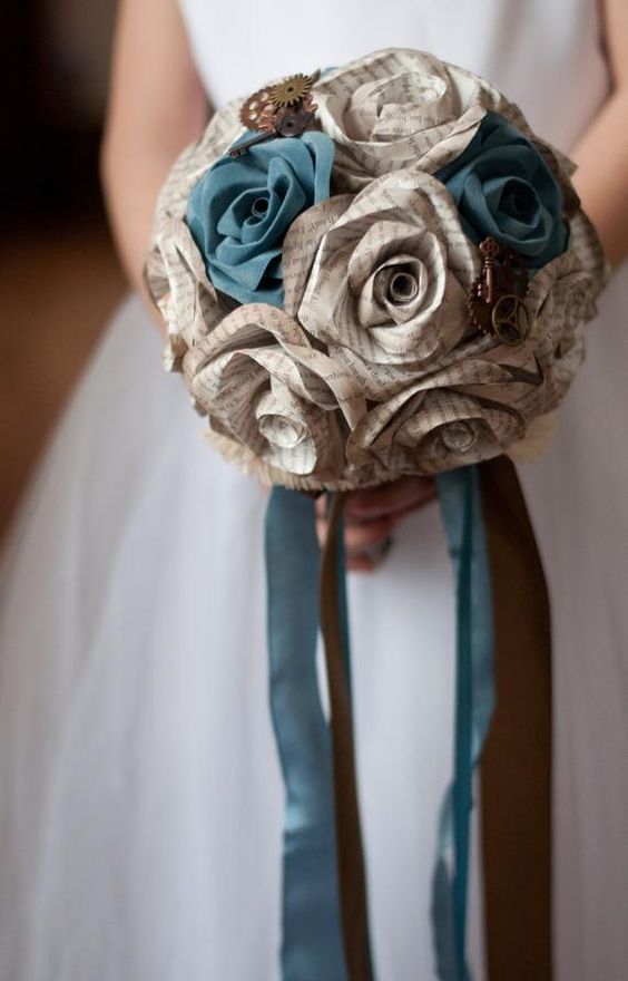 a vintage-inspired wedding bouquet made of newspaper flowers and ribbons and decorated with steampunk pieces is a very cool idea