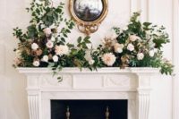 a wall-mounted mirror in a refined frame, blush and neutral blooms and greenery for an exxquisite and stylish look