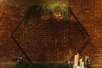 an industrial meets rustic space with a hex arch with greenery, wooden benches, candles and blooms