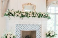 elegant fireplace decor with lush white blooms and greenery is a cool idea to accent the fireplace