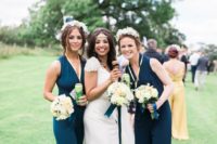 fitting sleeveless teal bridesmaid jumpsuits with V-necklines and heeled sandals for a modern wedding