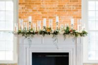modern and delicate fireplace styling with floating candles and those in elegant candleholders, greenery and bright blooms