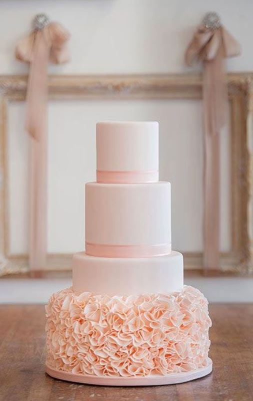 a rose quartz wedding cake with ribbons and a ruffle tier looks refined, chic and very romantic