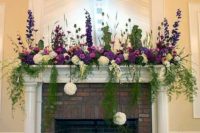 purple and white blooms, greenery hanging don and soem greenery arrangements plus candles in vintage glasses