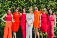 mismatching fuchsia-colored bridesmaid jumpsuits with sashes and pockets for a colorful summer wedding