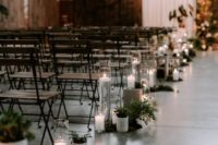 white curtains for a backdrop and aisle decor with greenery and candles for a modern industrial wedding space